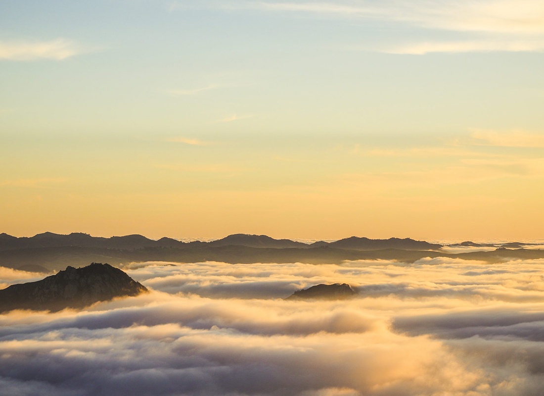 Blog - Clouds With Exposed Tips of Mountains and Hills During a Hazy Sunrise
