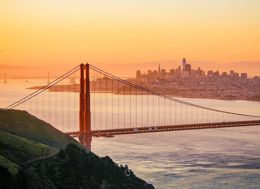 Health Care Security Ordinance HCSO Compliance - Aerial View of The Golden Gate Bridge With the City of San Francisco in the Background and Hilly Roads in the Foreground During Sunrise